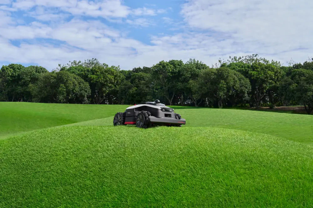 Dreame AI lawn mower cutting across a sloped lawn with four-wheel drive