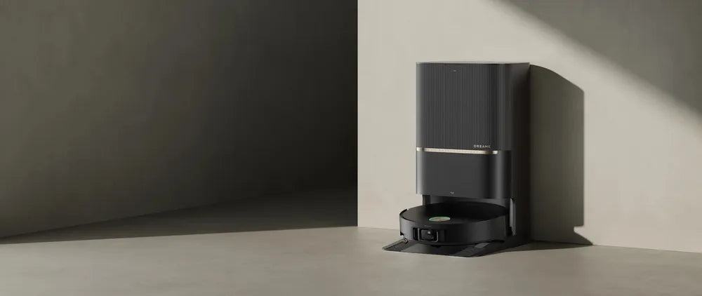 Dreame robot vacuum parked in its self-emptying dock, tucked into a corner against the wall