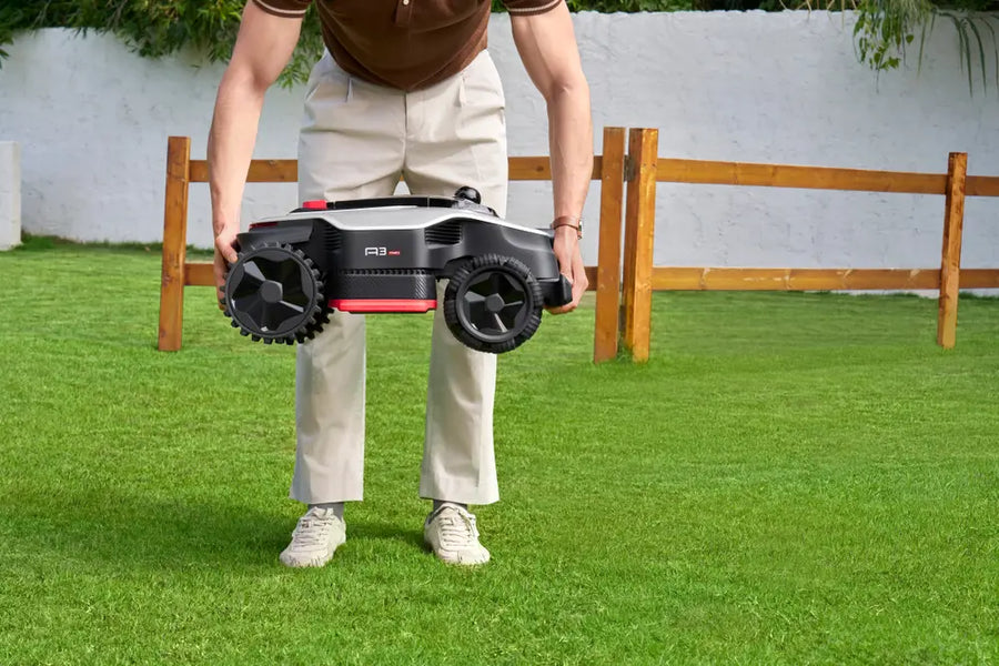 Person lifting a Dreame mower off the lawn, which triggers an alert