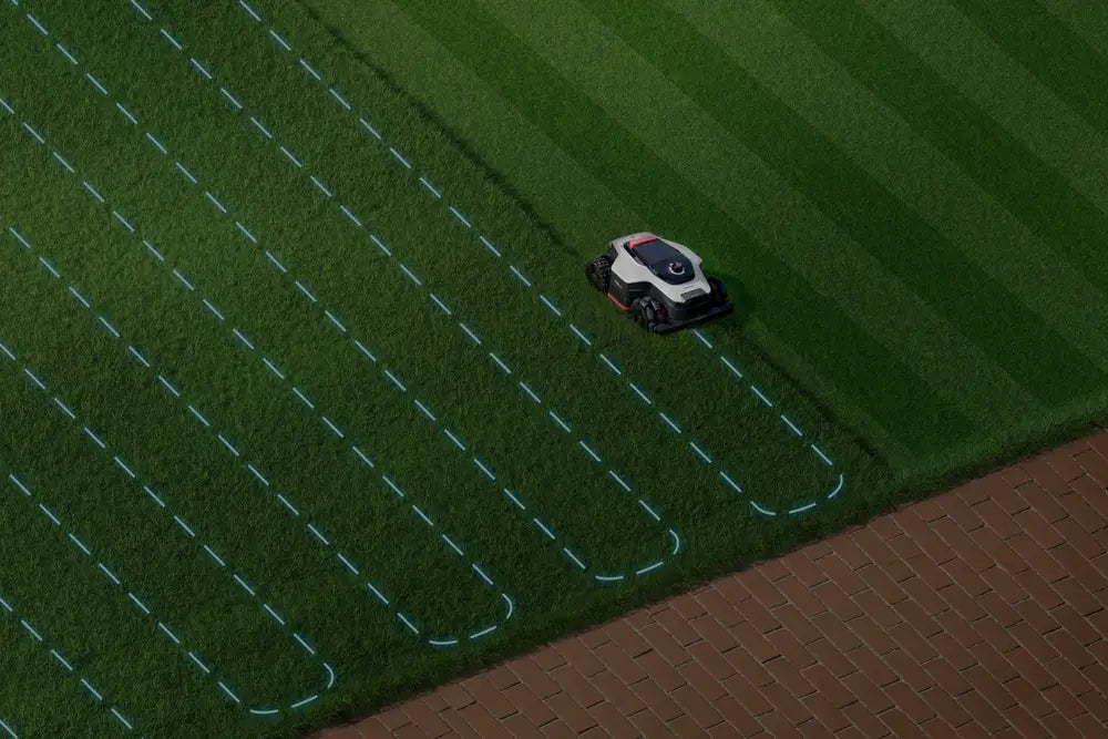 Dreame A3 AWD robot lawn mower cutting striped mowing paths at dusk.