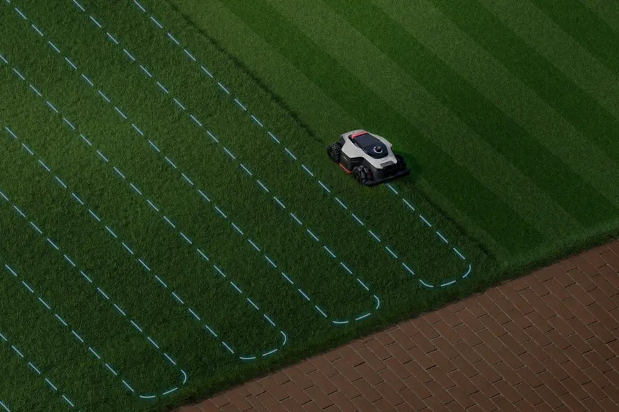 Dreame A3 AWD robot lawn mower cutting striped mowing paths at dusk.